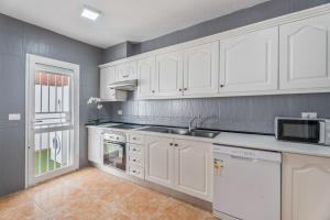 een keuken met witte kasten en een spoelbak bij Ocean View Costa Adeje in Adeje