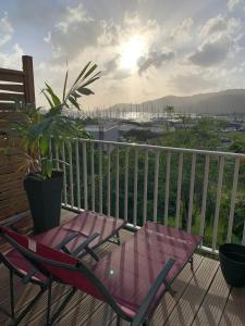 a deck with a table and chairs on a balcony at Appartement spacieux avec vue sur la mer à Le Marin in Le Marin