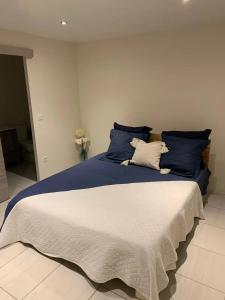 a bedroom with a large bed with blue and white pillows at Appartement spacieux avec vue sur la mer à Le Marin in Le Marin