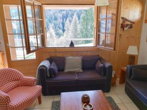 a living room with a couch and a large window at Vieux Chalets B 03 in Grimentz