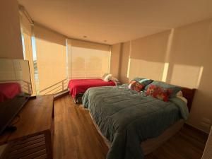 a bedroom with two beds and a couch and a window at San Alfonso del Mar 7P in Algarrobo
