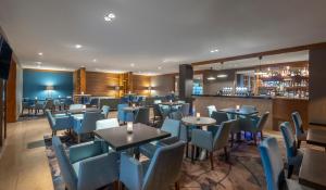 a restaurant with tables and chairs and a bar at Clayton Hotel Liffey Valley in Clondalkin 