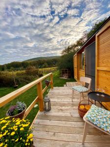 a wooden deck with a table and chairs on it at Off-grid maringotka Cibéba in Rača