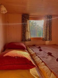 a bed in a room with a window at Off-grid maringotka Cibéba in Rača +9 photos