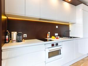a kitchen with white cabinets and a sink at Penthouse Studio with Terrace and City View - 5 mins walk to Hauptbahnhof Train Station in Vienna