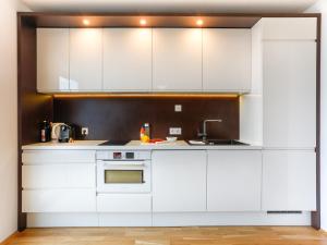 a kitchen with white cabinets and a sink at Penthouse Studio with Terrace and City View - 5 mins walk to Hauptbahnhof Train Station in Vienna