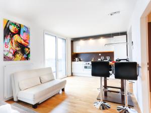 a living room with a couch and a kitchen at Penthouse Studio with Terrace and City View - 5 mins walk to Hauptbahnhof Train Station in Vienna