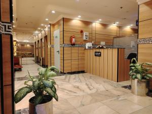 a lobby with two potted plants in a building at فندق فجر الرسالة in Al ‘Azīzīyah