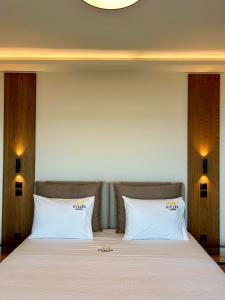 a bed with two white pillows in a room at Kyllini Seaside Apartments & Rooms in Kyllini