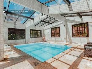 a swimming pool in a building with a blue floor at Kastel Pedra Bonita in Petrópolis