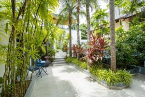a courtyard with palm trees and plants in a building at Villa Guenlaur 3 studios with kitchenette and pool in Ban Saiyuan (1)