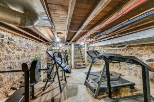 a gym with two treadmills and two bikes in a room at 6 Mi to Notre Dame Family Retreat with Deck and Yard in Mishawaka