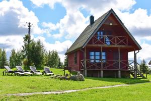 a large red barn with chairs and sheep in the grass at LAKE VIEW Resort - Sodyba in Skirlėnai +38 photos