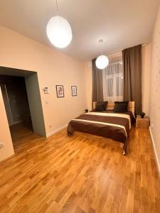 a bedroom with a bed and wooden floors and two lights at Apartament R48 in Dąbrowa Tarnowska