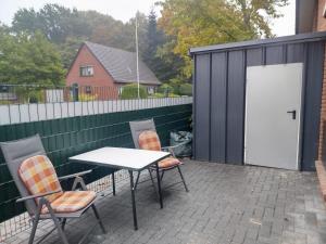 a patio with two chairs and a table and a building at Ferienwohnung Nordstern in Papenburg