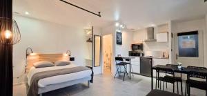 ein Schlafzimmer mit Bett und Schreibtisch und eine Küche in der Unterkunft WOOD - Gîte meublé & confort Drôme - Écolodgîte in Laveyron