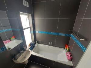 a bathroom with a bath tub and a sink at Chelmsford close in Oakdale