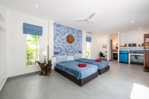 a bedroom with two beds and a blue wall at Villa Guenlaur 3 studios with kitchenette and pool in Ban Saiyuan (1) +32 photos