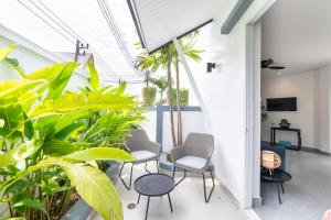 an indoor garden with chairs and plants in a room at Villa Guenlaur 3 studios with kitchenette and pool in Ban Saiyuan (1)