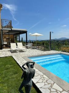 une statue d'une femme debout à côté d'une piscine dans l'établissement Spiti Espede, à Ágios Márkos