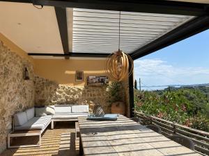 un patio avec un canapé et une suspension lumineuse dans l'établissement Spiti Espede, à Ágios Márkos