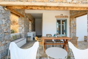 a patio with a wooden table and chairs at Ormos Seaside Villas, by Amorgos Holiday Homes in Amorgos