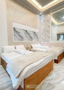 - 2 lits dans une chambre avec une fresque murale dans l'établissement Grand House Nexura Collection, à Diyeng