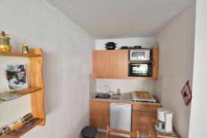 Una pequeña cocina con fregadero y microondas. en Comfortable 30m balcony and mountain view, en Briançon