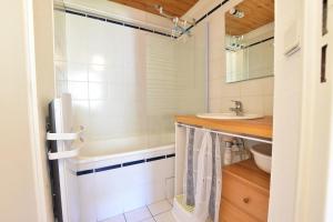 un baño con ducha y lavabo en Comfortable 30m balcony and mountain view, en Briançon 2 fotos más