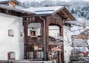 Cabaña de madera con balcón en la nieve en Plazores, en San Vigilio Di Marebbe