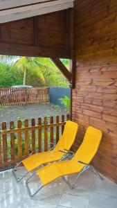 een paar gele stoelen op een veranda bij Maison confortable à Petit-Canal avec jardin 52 m² in Petit-Canal