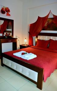 a bedroom with a red bed with a red comforter at Relax pozar in Kato Loutraki
