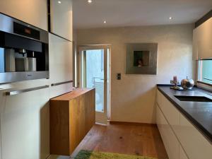 a kitchen with a sink and a counter top at KOSIS Townhouse mit Spa Zugang im KOSIS Sports Lifestyle Hotel in Fügen +8 photos