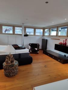 a room with a bed and a couch and a tv at KOSIS Townhouse mit Spa Zugang im KOSIS Sports Lifestyle Hotel in Fügen