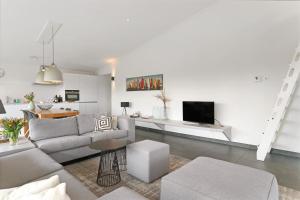 a living room with a couch and a tv at Seaside Family Villa 6p - Direct bij het Strand - Villa 24 in Ouddorp