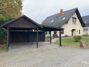 a large garage with a black roof in front of a house at Ferienwohnung Dorfliebe Minden by Engelmann in Minden