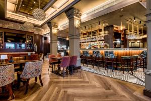 ロンドンデリーにあるWalled City Hotelのテーブルと椅子とバーのあるレストラン