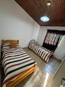a bedroom with two beds and a window at Casa Bahia in Concepción del Uruguay