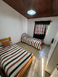 a bedroom with two beds and a window at Casa Bahia in Concepción del Uruguay