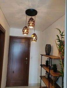 ein Flur mit drei Lampen und einer braunen Tür in der Unterkunft Equipetrol departamento minino 2dias in Hamacas