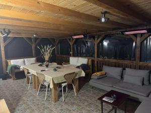 a room with a table and chairs and a couch at Casa Tihna in Băile Olăneşti