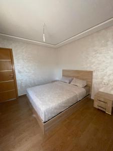 a bedroom with a bed and a wooden floor at إقامة الرياض الأطلس in Beni Mellal