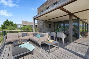 un patio avec un canapé et une table sur une terrasse dans l'établissement Dune & Lakeview Villa 6p - Luxe, Lounge & Verwarmd Terras - Villa 30, à Ouddorp