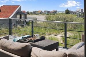 - un salon avec un canapé et une table sur un balcon dans l'établissement Dune & Lakeview Villa 6p - Luxe, Lounge & Verwarmd Terras - Villa 30, à Ouddorp