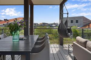 d'une terrasse avec une table et un hamac. dans l'établissement Dune & Lakeview Villa 6p - Luxe, Lounge & Verwarmd Terras - Villa 30, à Ouddorp