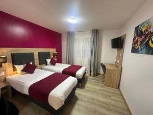 ブリュマトにあるHôtel NOROTELの赤い壁の客室で、ベッド2台が備わります。