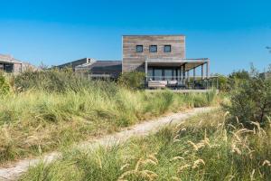 a house on top of a hill with a dirt road at Dune & Lakeview Villa 6p - Luxe, Lounge & Verwarmd Terras - Villa 30 in Ouddorp