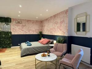 a bedroom with a bed and a table and chairs at Le Rom'Antik in Noyal-Pontivy