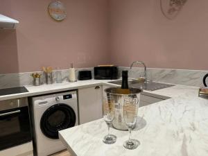 a kitchen counter with two wine glasses and a sink at Le Rom'Antik in Noyal-Pontivy