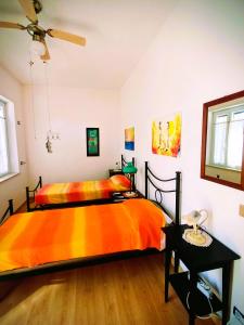 a bedroom with a bed with an orange blanket at La Villetta di Odisseo in Terracina +17 photos